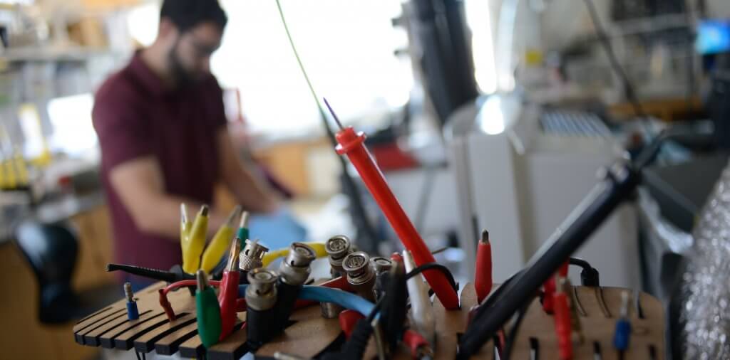 A student works with test equipment at an electronics lab bench